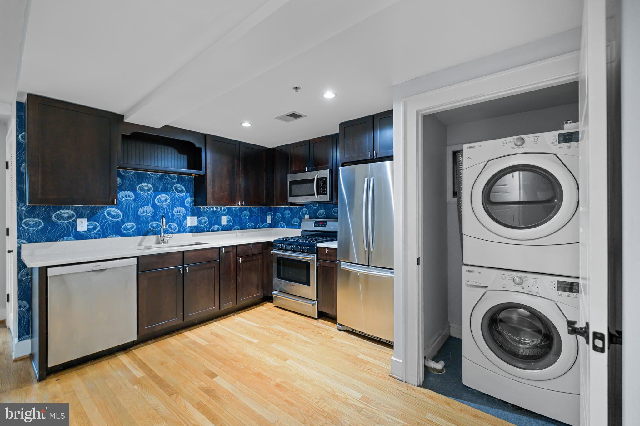 1109 M Street Northwest, Unit 1 Washington, DC 20005 - Photo 6 of 32 a kitchen with stainless steel appliances granite countertop a refrigerator sink and cabinets
