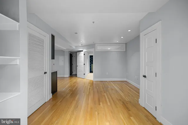 a view of a big room with wooden floor and a bathroom