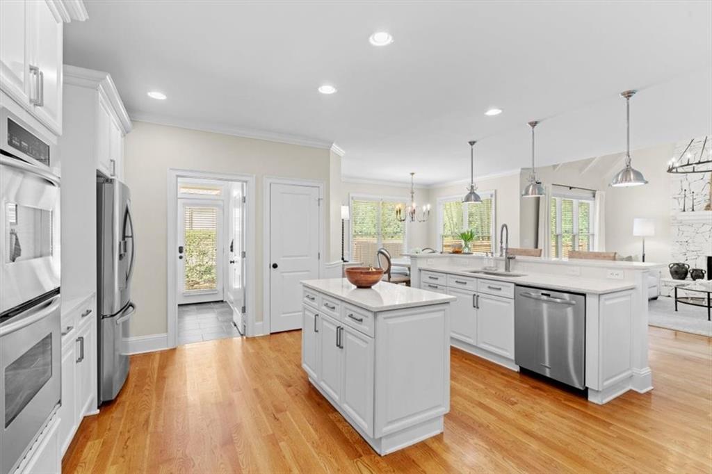 1002 Tyle Street Northwest Kennesaw, GA 30152 - Photo 25 of 83 a kitchen with stainless steel appliances a stove top oven a sink a refrigerator and white cabinets with wooden floor