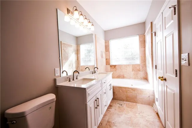a bathroom with a double vanity sink toilet and shower