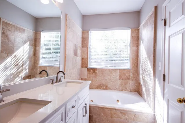 a bathroom with a tub sink and a window