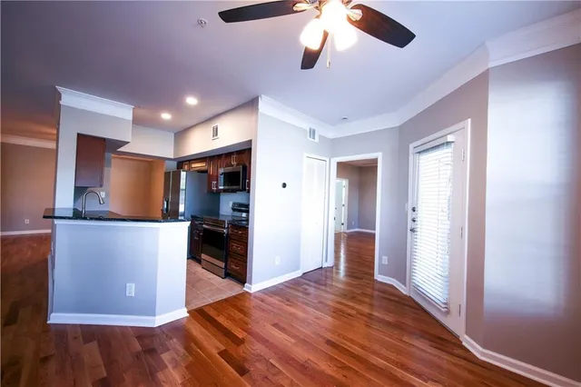 a view of a kitchen with a refrigerator a ceiling fan and wooden floor