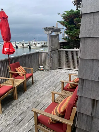 a balcony with wooden floor table and chairs