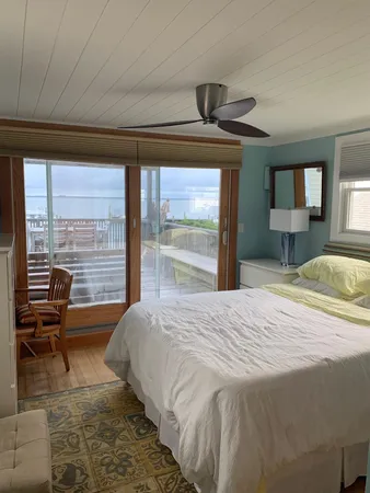 a bedroom with a bed and large windows