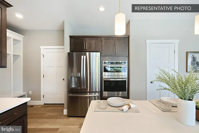 a large kitchen with lots of counter space a sink appliances and living room view