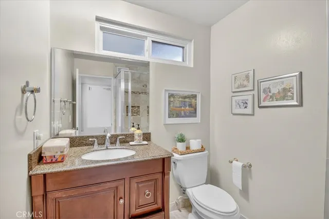 a bathroom with a double vanity sink toilet mirror and shower