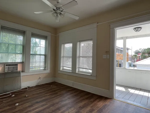 an empty room with wooden floor and windows