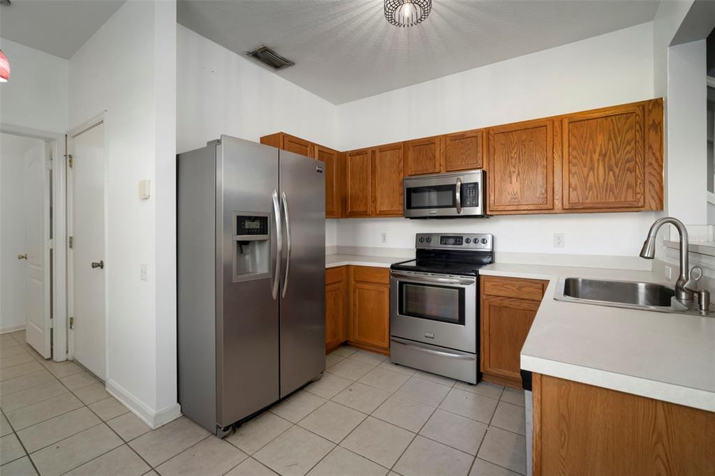 2802 Conch Hollow Drive Brandon, FL 33511 - Photo 21 of 74 a kitchen with granite countertop a refrigerator and a stove top oven