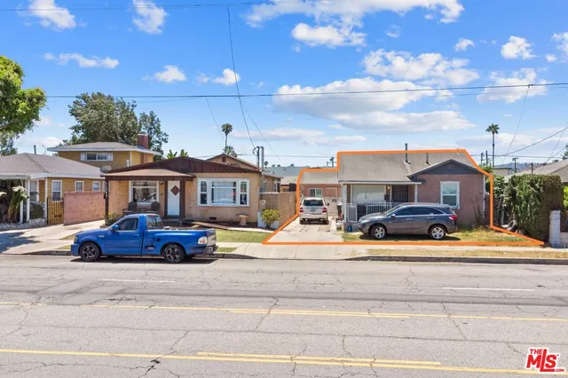 a front view of a house with garden and trees