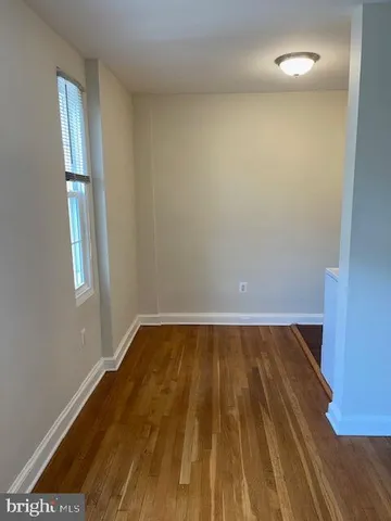 a view of a room with wooden floor and windows