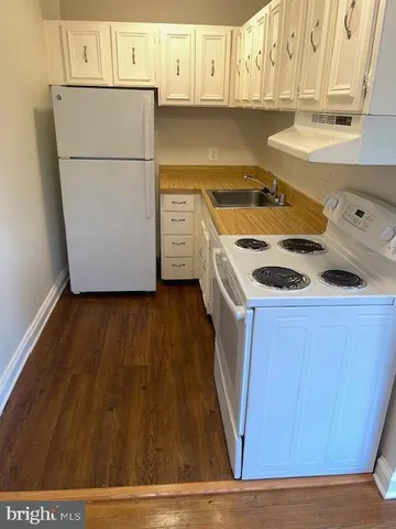 a kitchen with a sink a stove and cabinets
