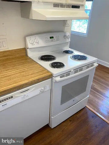 a white stove top oven sitting inside of a kitchen