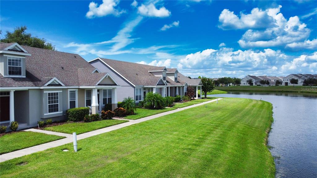 13550 Carroway Street Windermere, FL 34786 - Photo 1 of 1 a view of a white house in front of a big yard plants and large trees