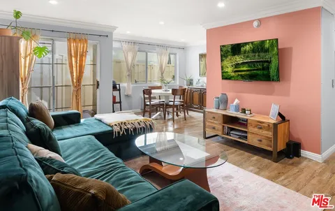 a living room with furniture a flat screen tv and a floor to ceiling window