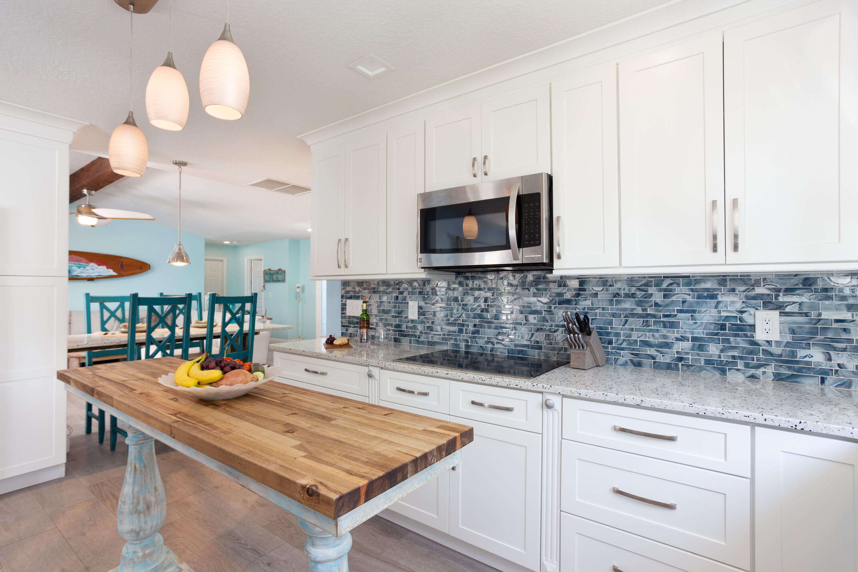 401 Surf Road Melbourne Beach, FL 32951 - Photo 23 of 94 a kitchen with stainless steel appliances granite countertop a sink a microwave cabinets and a view of living room