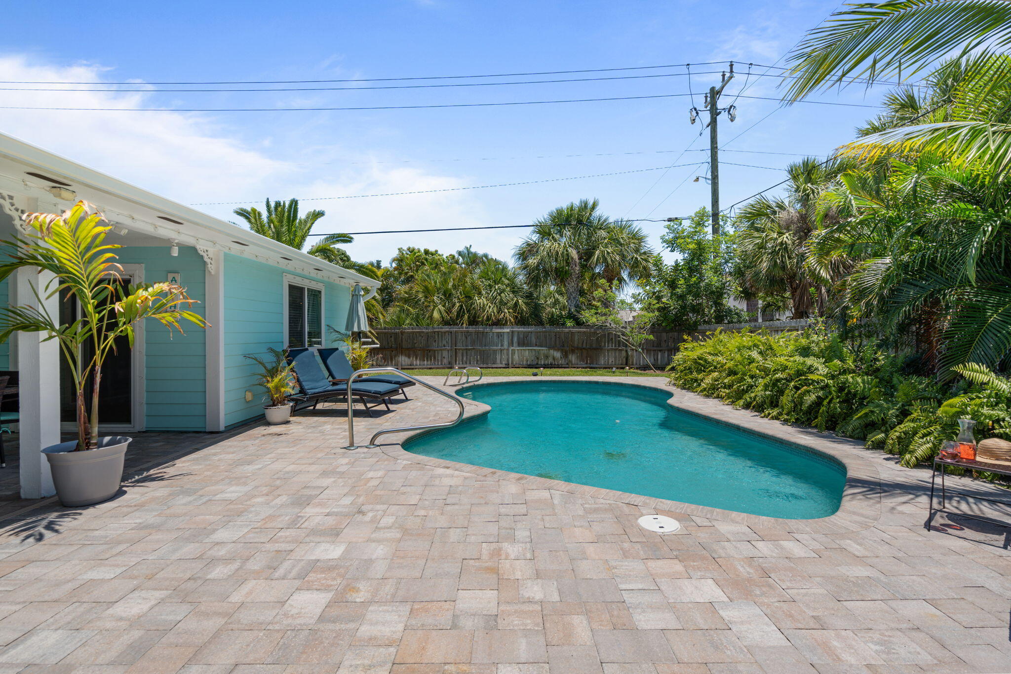 401 Surf Road Melbourne Beach, FL 32951 - Photo 81 of 94 a view of a patio with table and chairs potted plants with wooden fence