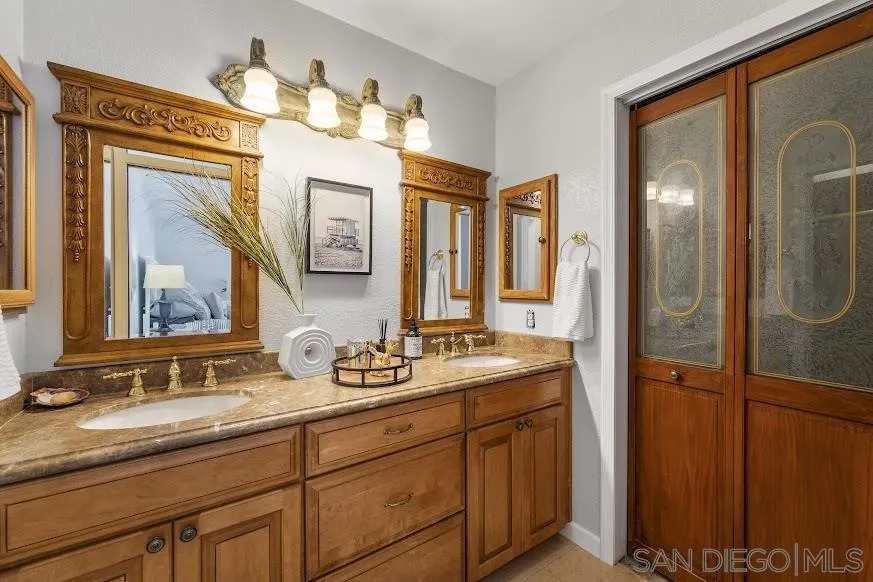 156 Little Oaks Road Encinitas, CA 92024 - Photo 14 of 38 a bathroom with a double vanity sink and a mirror