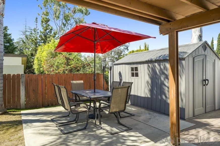 156 Little Oaks Road Encinitas, CA 92024 - Photo 29 of 38 a patio with a table and chairs under an umbrella