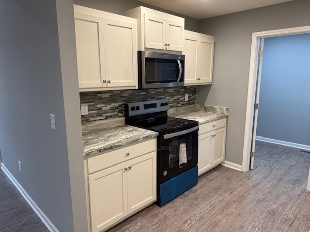 1415 Old Estill Springs Road Tullahoma, TN 37388 - Photo 9 of 25 a kitchen with stainless steel appliances granite countertop a stove a microwave and a sink