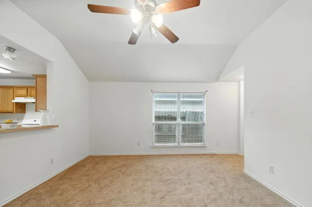 an empty room with chandelier fan