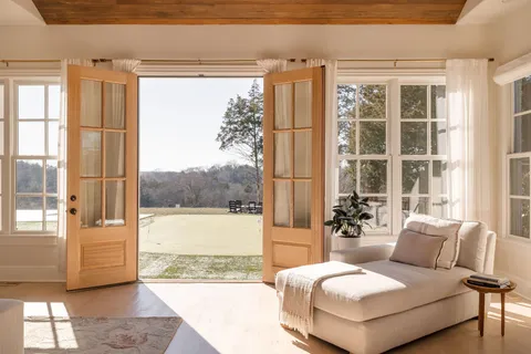a bedroom with furniture and large windows