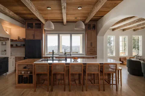 a dining hall with stainless steel appliances granite countertop a dining table chairs and granite counter tops