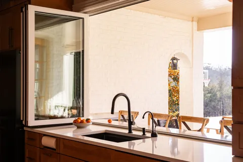 a view of a sink with a dining table and chair with a large window