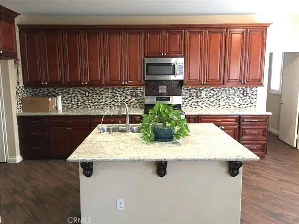 a kitchen with sink a microwave and cabinets