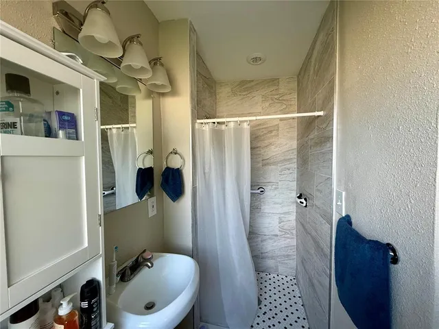 a bathroom with a sink a toilet a shower and a mirror