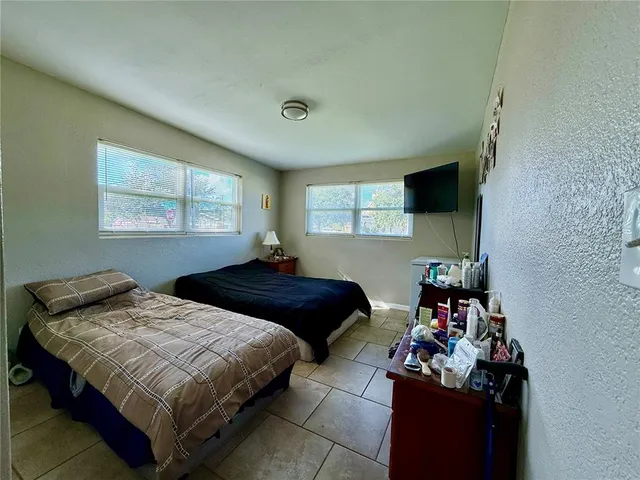 a bedroom with two bed and a window