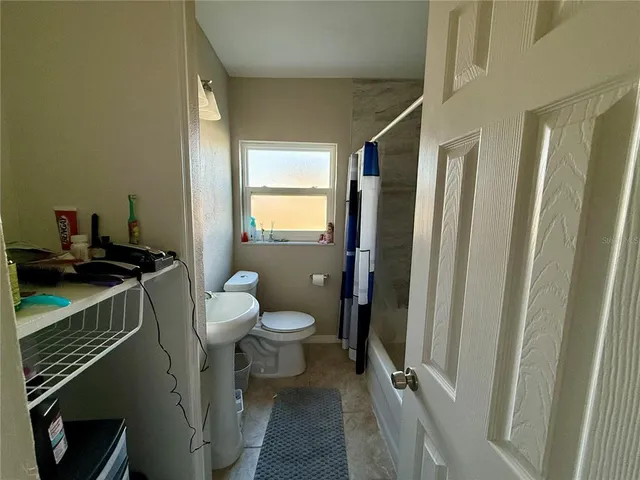 a bathroom with a sink a toilet a mirror and shower