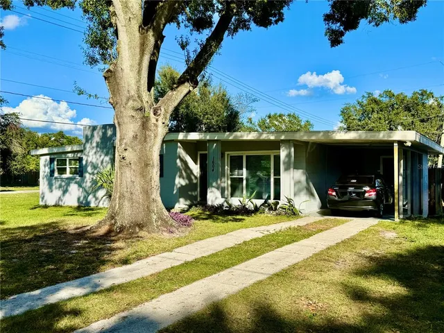a view of a house with backyard porch and sitting area
