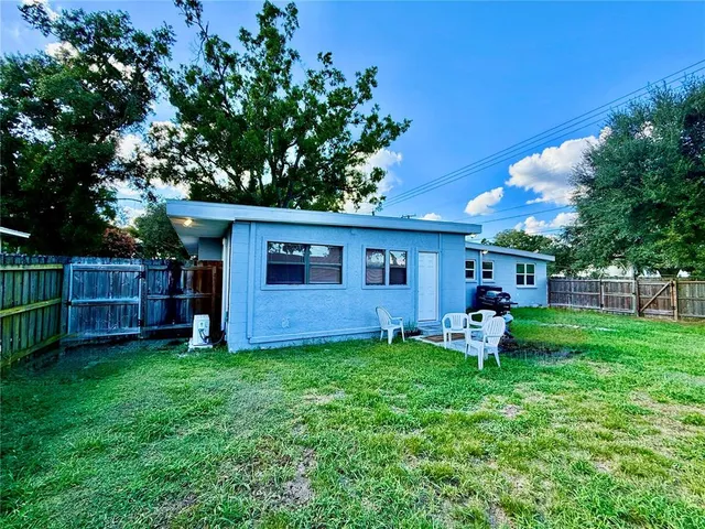 a view of a chair and table in backyard of the house