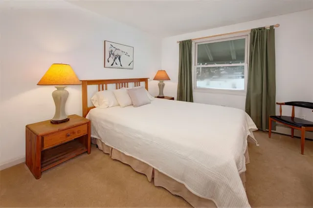 a bed sitting in a bedroom next to a window