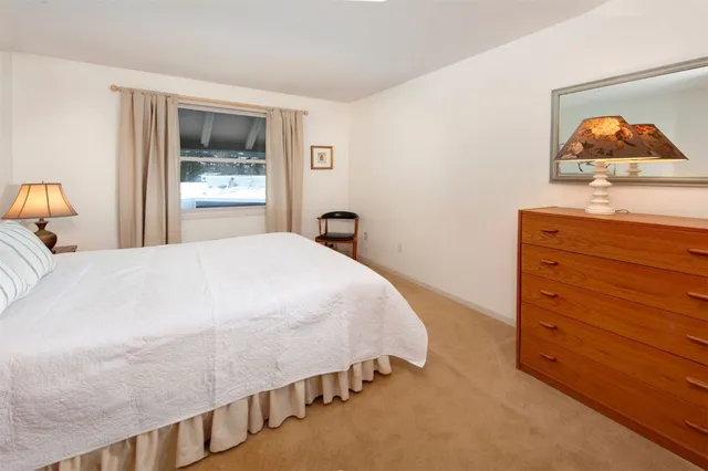 a bedroom with a bed and a painting on the wall