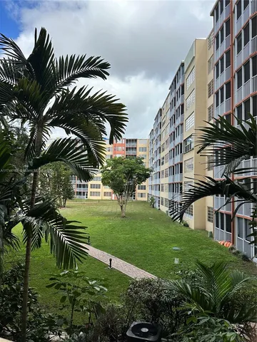 a view of a big building with a big yard and plants