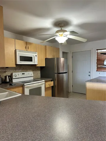 a kitchen with stainless steel appliances a stove a refrigerator and a sink