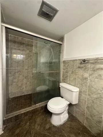 a bathroom with a toilet and a shower