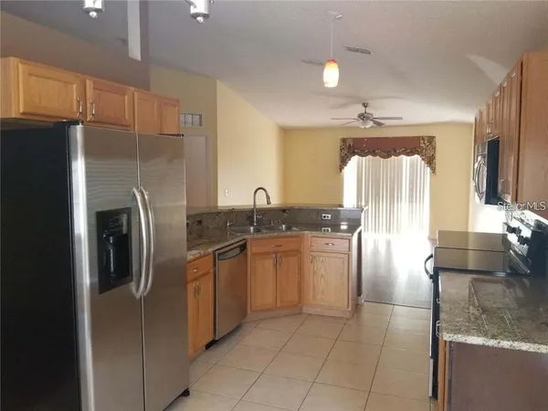 a kitchen with stainless steel appliances granite countertop a refrigerator and a sink
