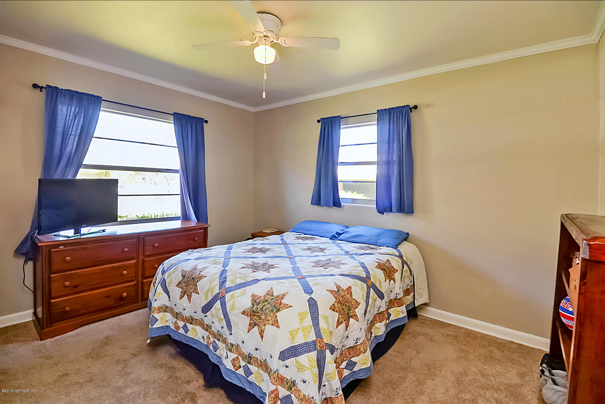 7442 Melvin Road Jacksonville, FL 32210 - Photo 11 of 17 a bedroom with a bed and a flat tv screen on the dresser