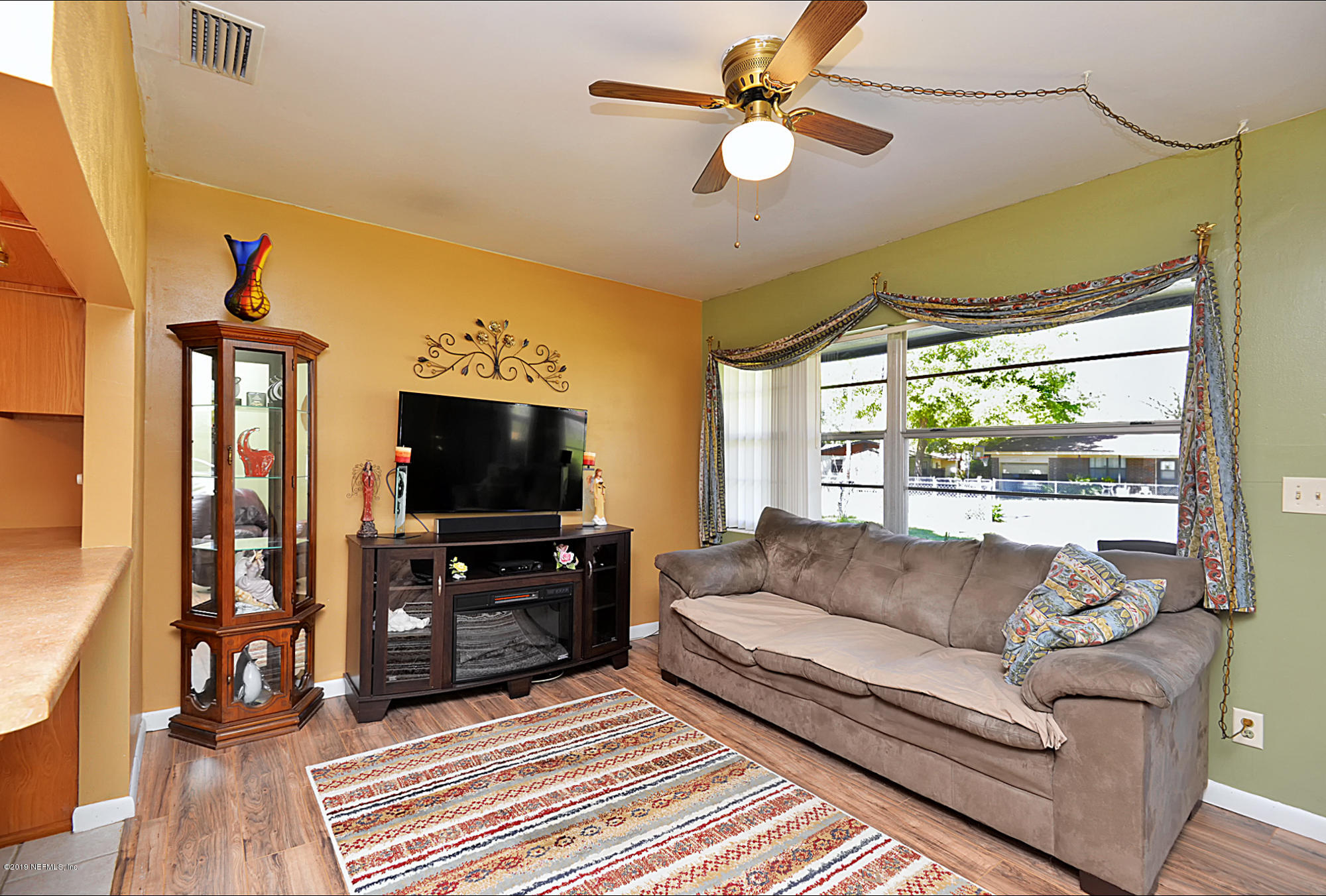 7442 Melvin Road Jacksonville, FL 32210 - Photo 4 of 17 a living room with furniture and a flat screen tv