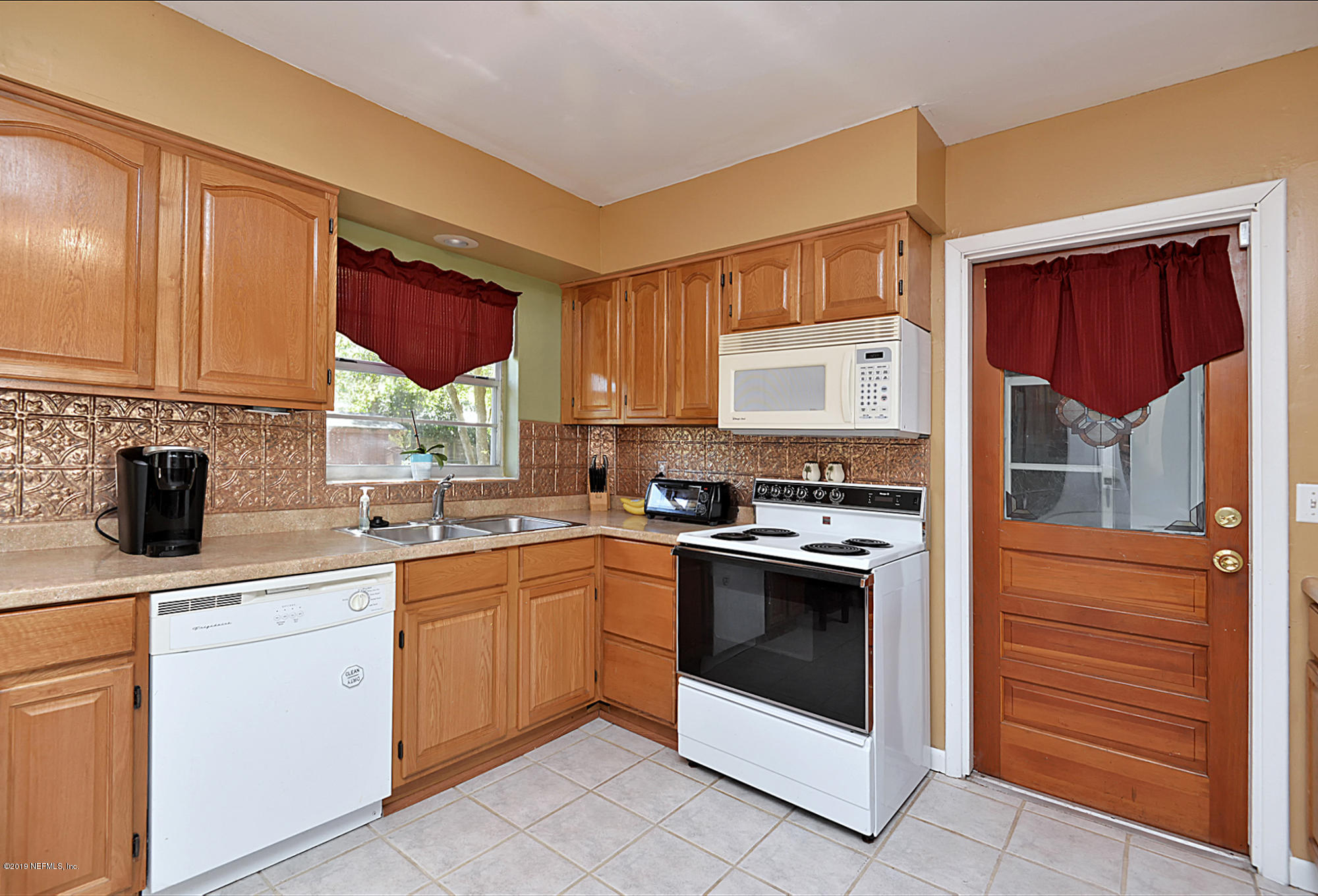 7442 Melvin Road Jacksonville, FL 32210 - Photo 7 of 17 a kitchen with a stove sink and cabinets
