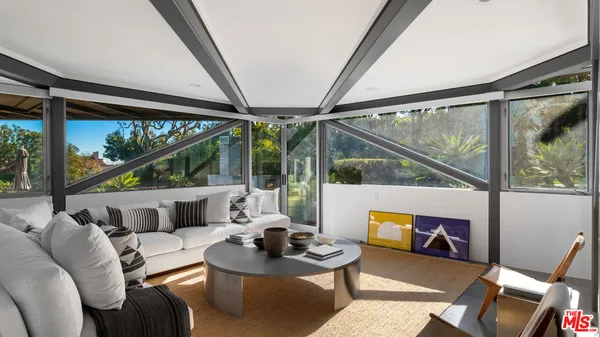 a living room with furniture and a floor to ceiling window