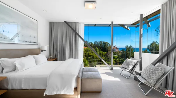 a living room with furniture a rug and a floor to ceiling window