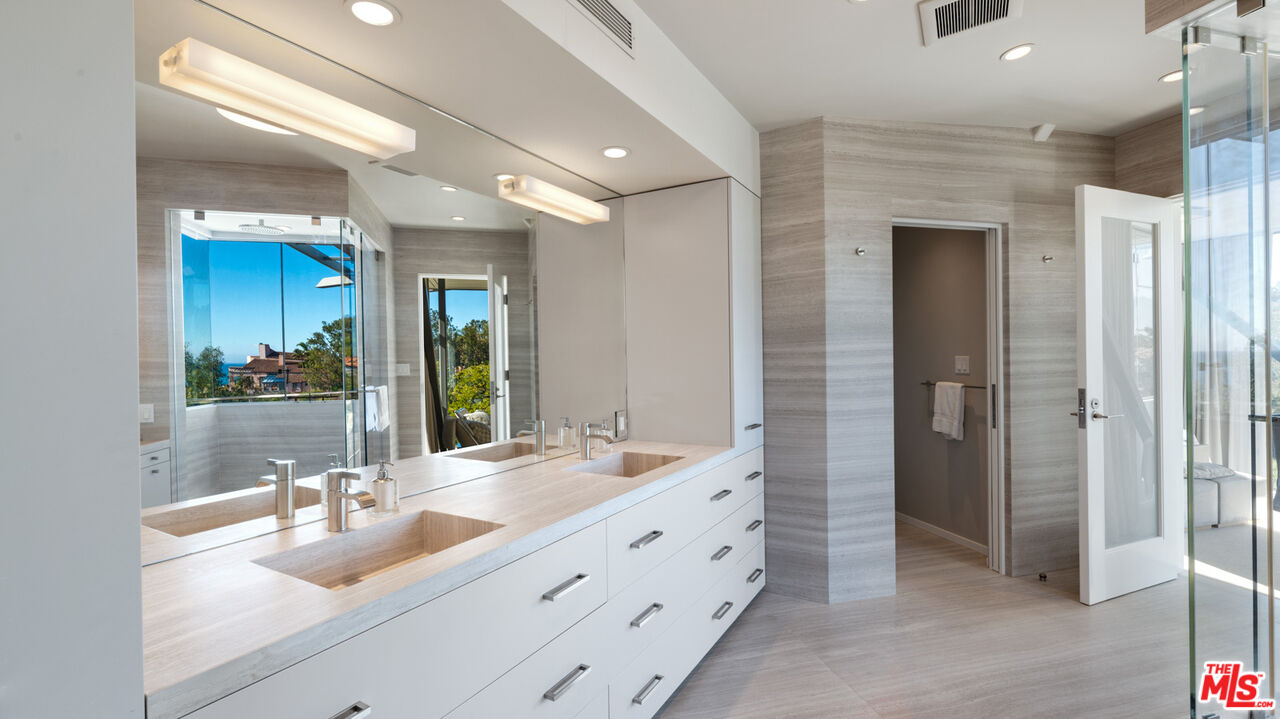 28827 Grayfox Street Malibu, CA 90265 - Photo 29 of 60 a bathroom with double vanity sinks and a large mirror