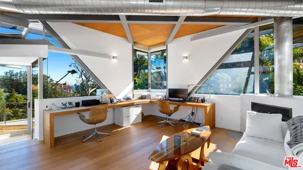 a bedroom with a bed and large windows