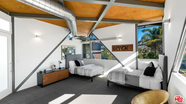 a living room with furniture large windows and wooden floor