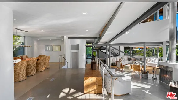 a living room with furniture large window and wooden floor