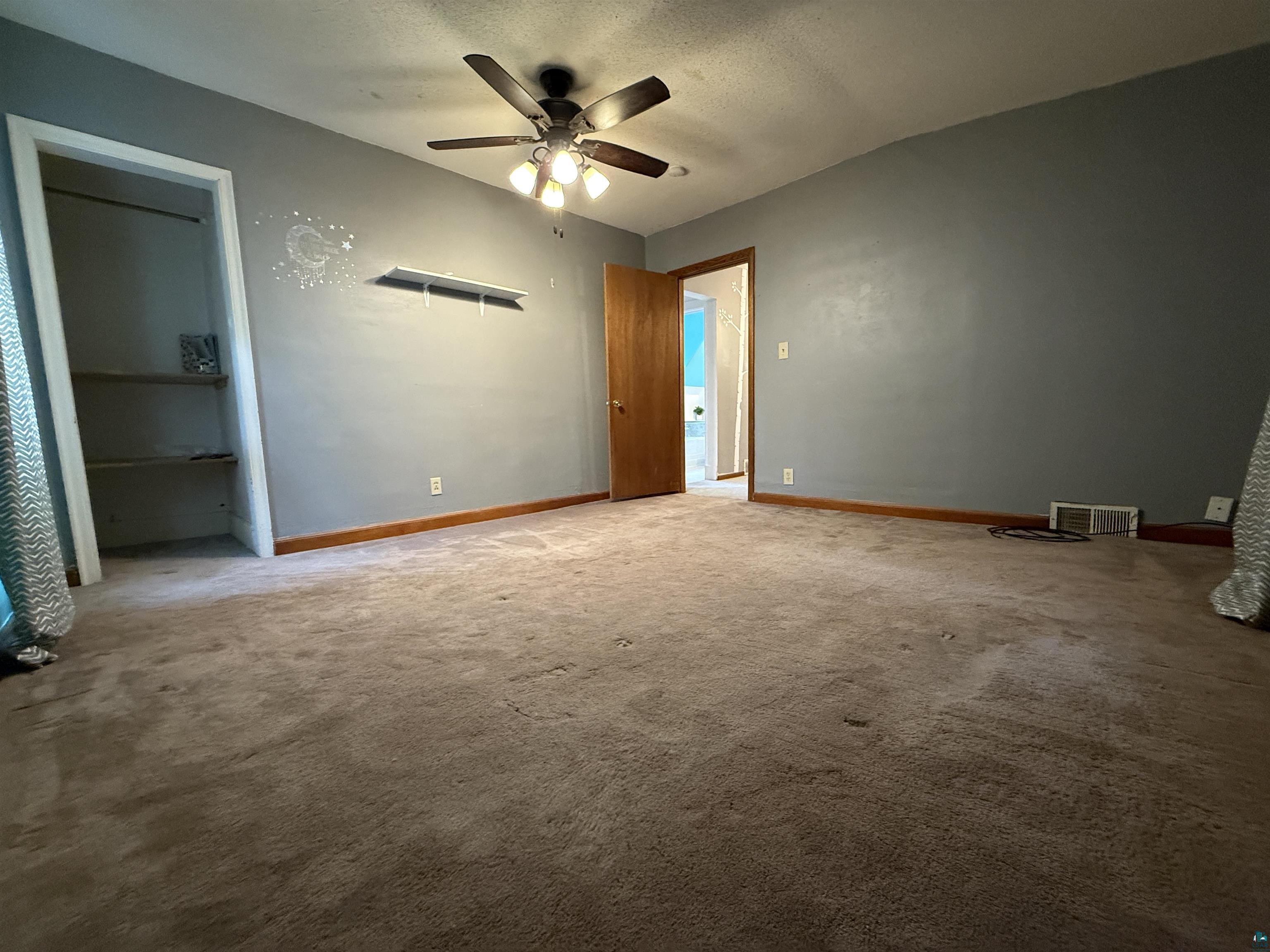 809 16th Street North Virginia, MN 55792 - Photo 33 of 44 Unfurnished bedroom featuring carpet, a textured ceiling, and ceiling fan