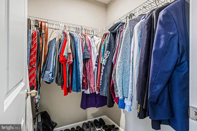 a view of walk in closet with clothes